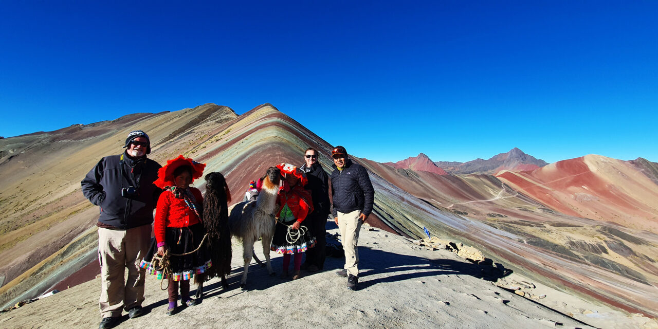 Group with local and alpacas visiting Rainbow Mountain in Peru